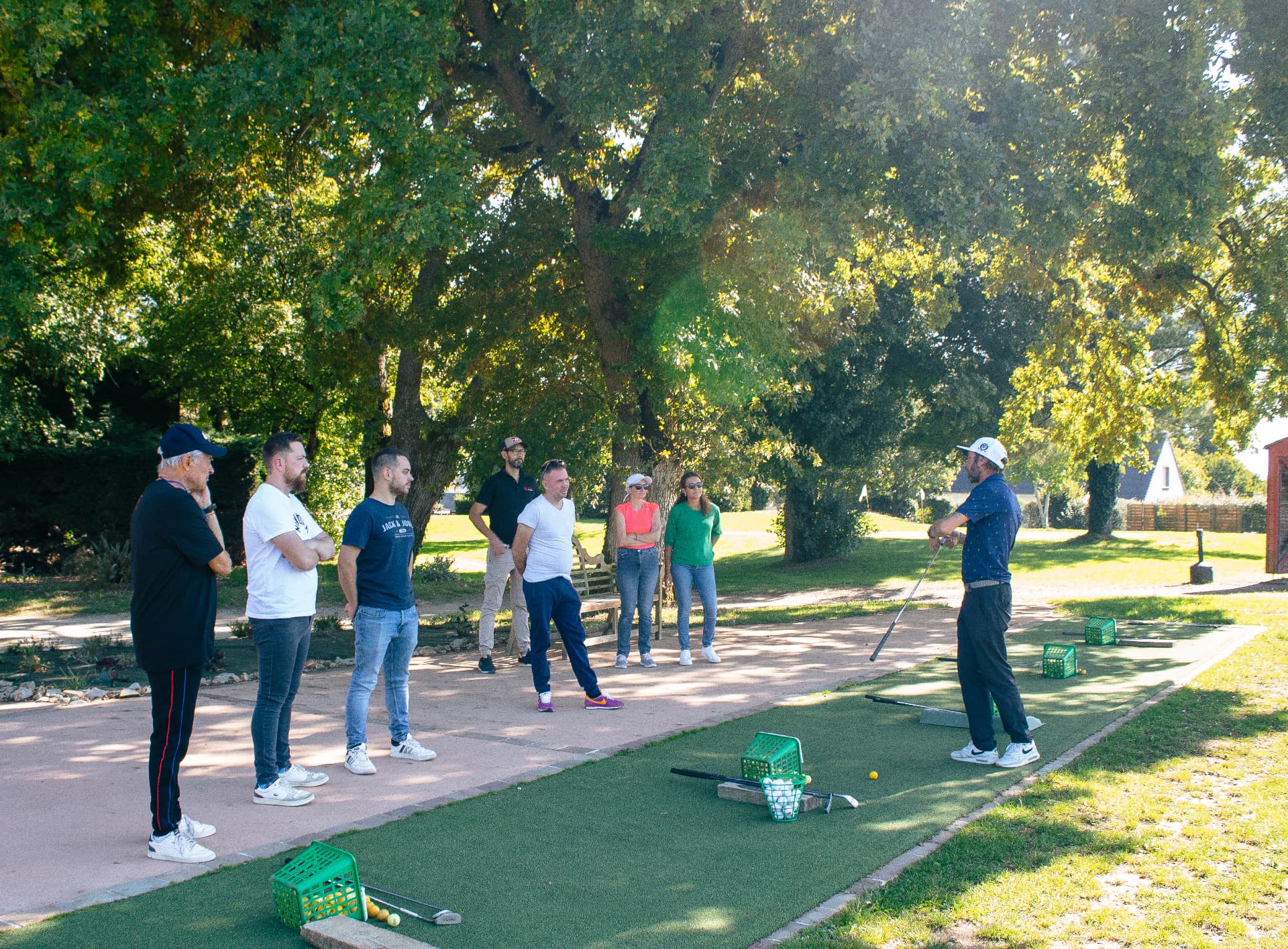 Professeur de golf encadrant un cours collectif au practice